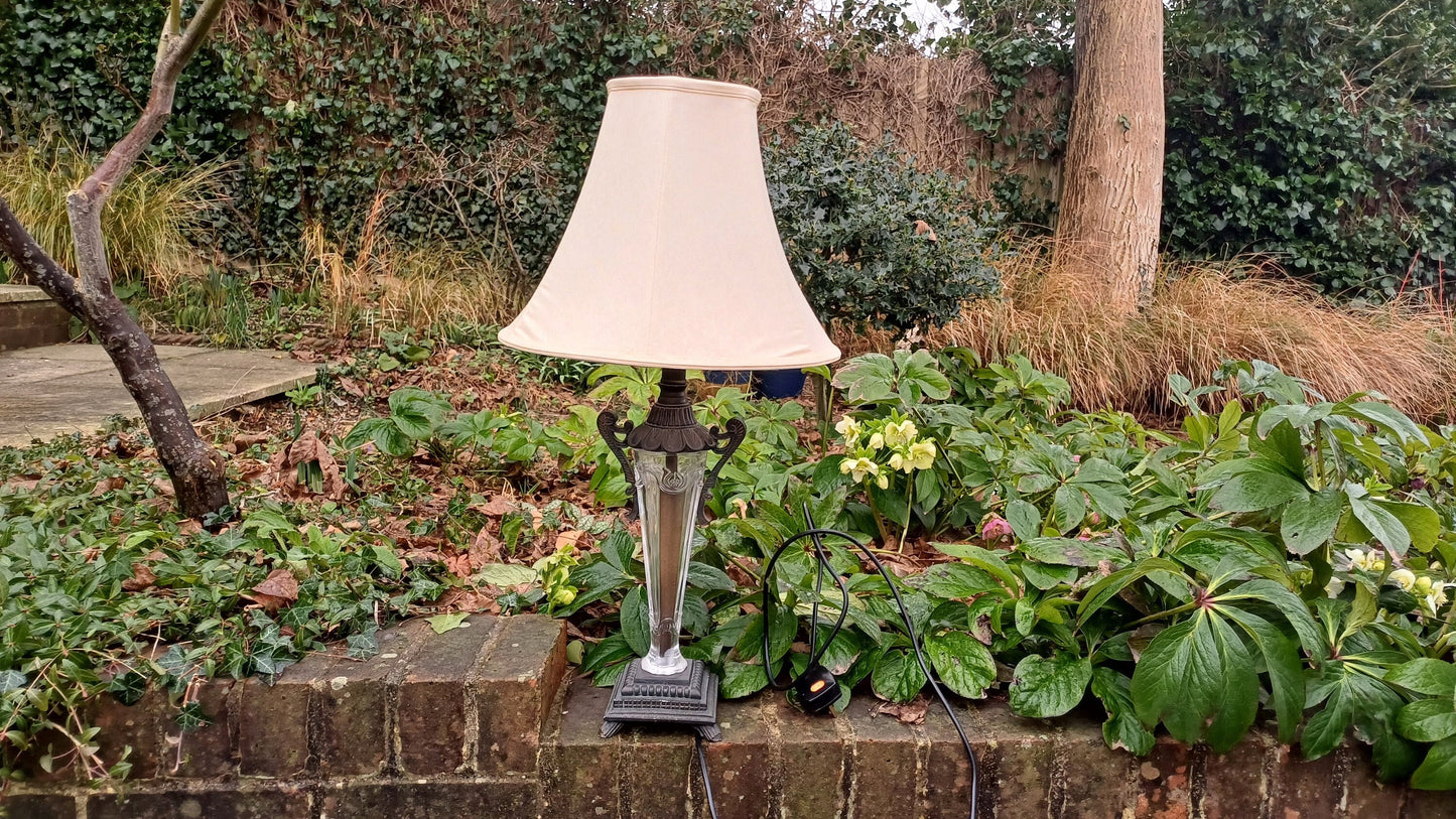 tall, metal and glass lampbase with a patterned jacquard cream shade