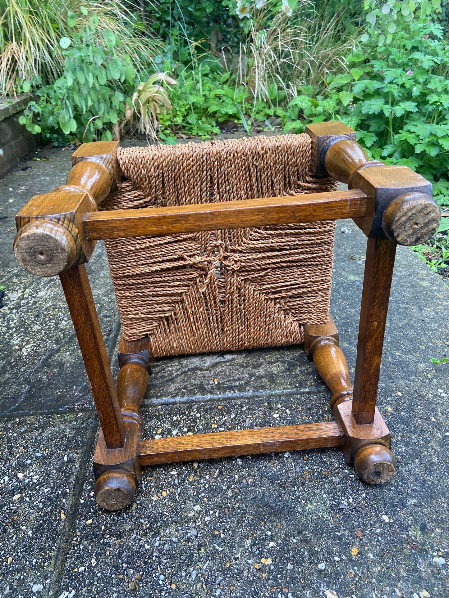 Early twentieth century vintage foot stool, wooden frame with string woven seat, authentic old stool, child stool