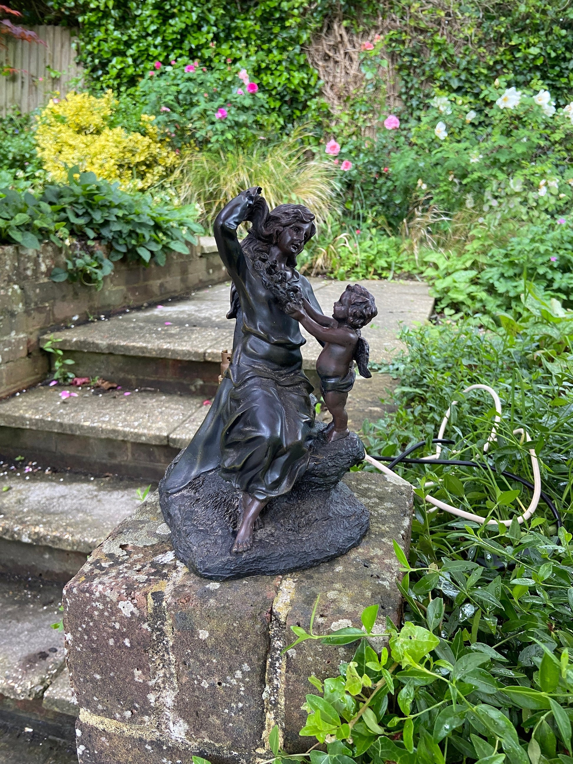 Widdop Bingham & Co made table lamp in black. Material could be resin, but it is finished in a bronze colour. Dark with slight hints of metallic through it. A woman and child, woman and cherub moulded lamp base, unfortunately missing the shade