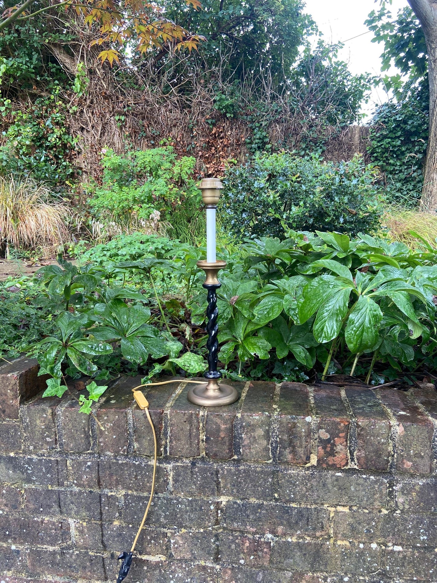 wonderful tall vintage table lamp. likely 1980s. made of a black china / ceramic with metal brassdetail and a white mock candle at the top. working condition