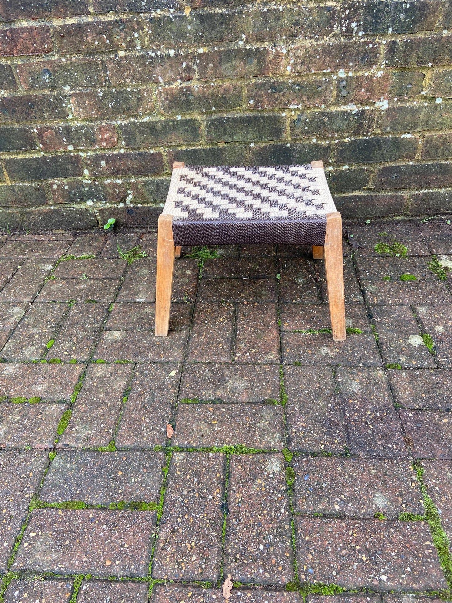 strong retro wooden stool with a strung seat. solid. slightly a frame legs. brown beige top.