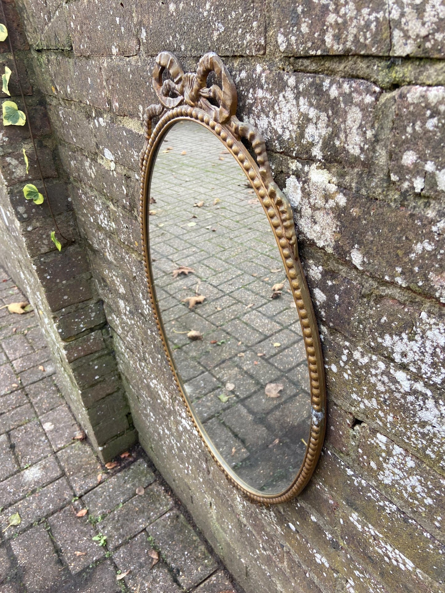 Delightful ornate vintage gilt metal framed oval mirror