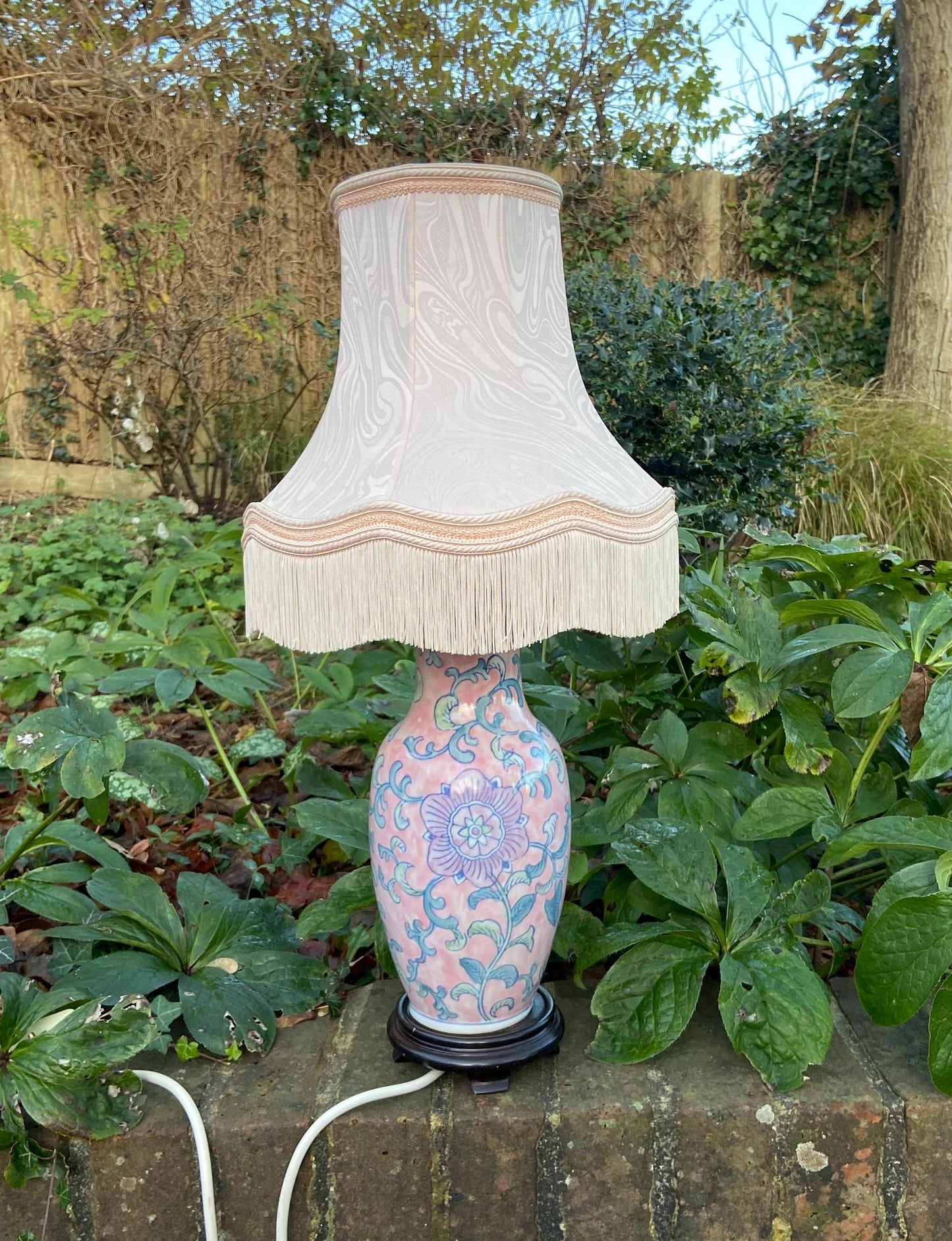 large oriental vase style ceramic lamp painted in blue and pink floral pattern. VGC. working vintage table lamp with avintage quality pink fringed shade.