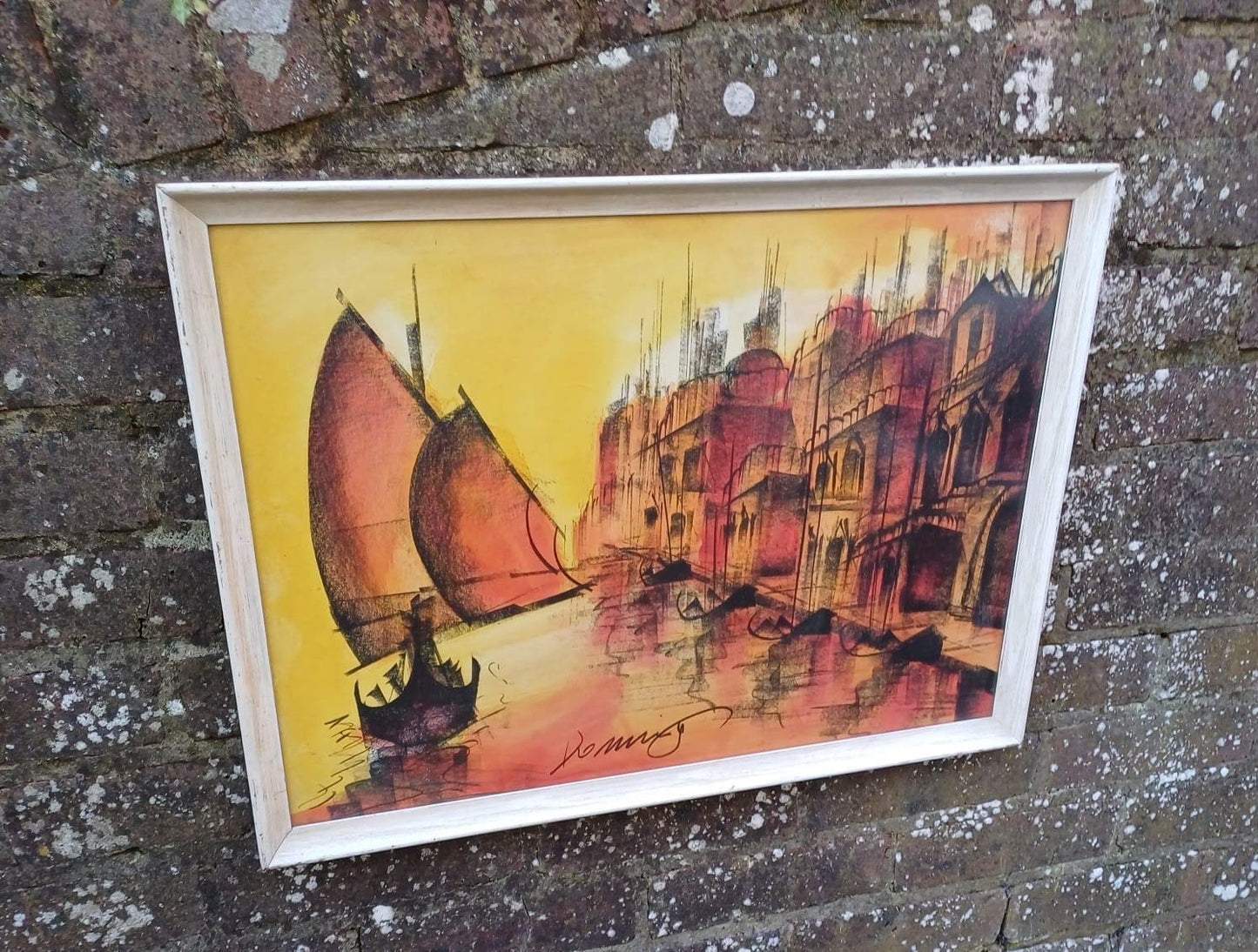 large retro print in oranges. likely sunset picture. signed. framed in white wooden frame. ready to hang