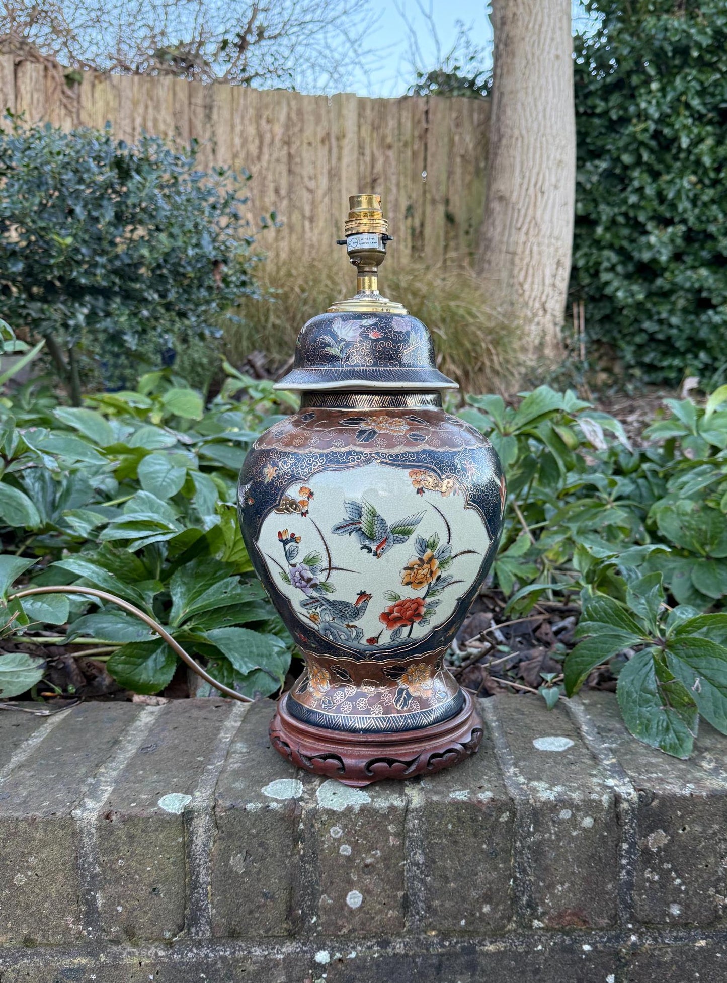 oriental ginger jar very large lamp. carved wooden base. hand painted design with gold finish. mythical creatures andflowers. very attractive. working vintage table lamp