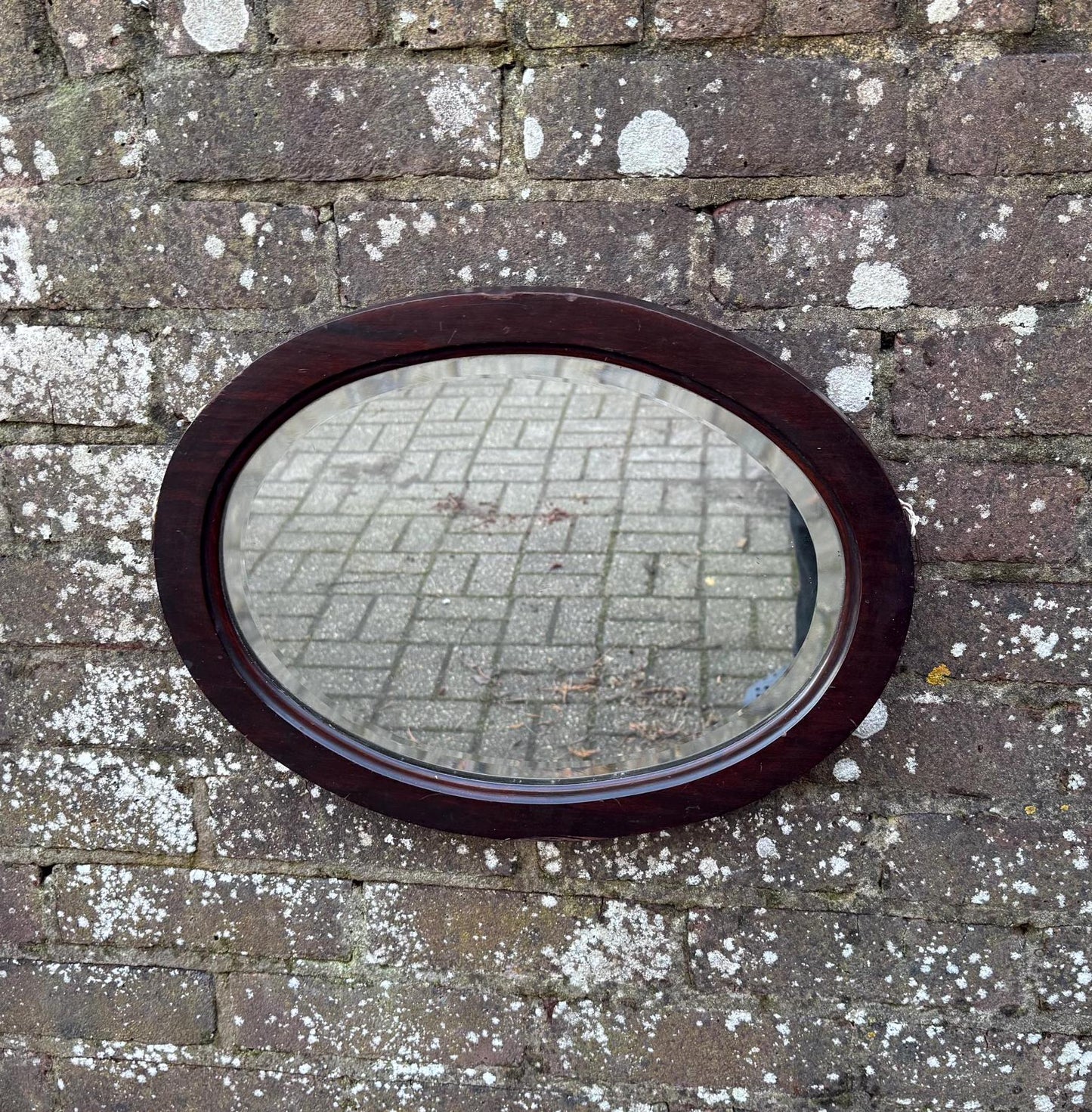 lovely vintage wooden mirror with bevelled glass, in a oval wooden frame. likely antique.