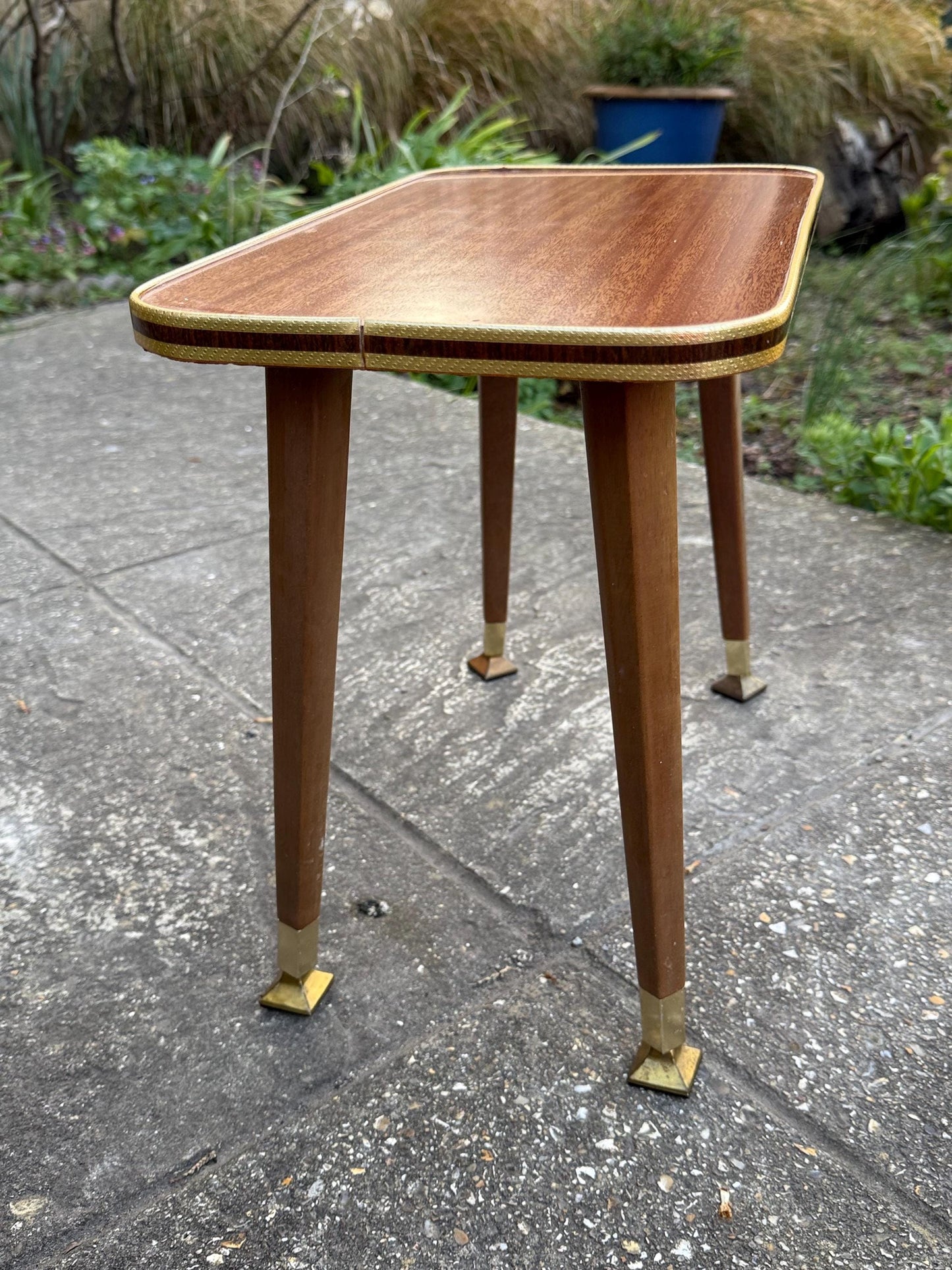 Mid-century modern small table with laminated woodgrain top, tapered legs and metal swivel capped feet