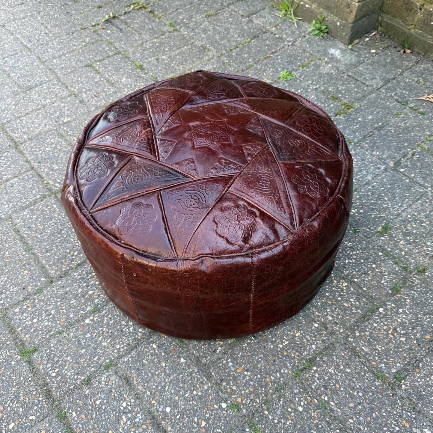 brown leather pouf. retro in age. lovely pattern top. beanbag filling.
