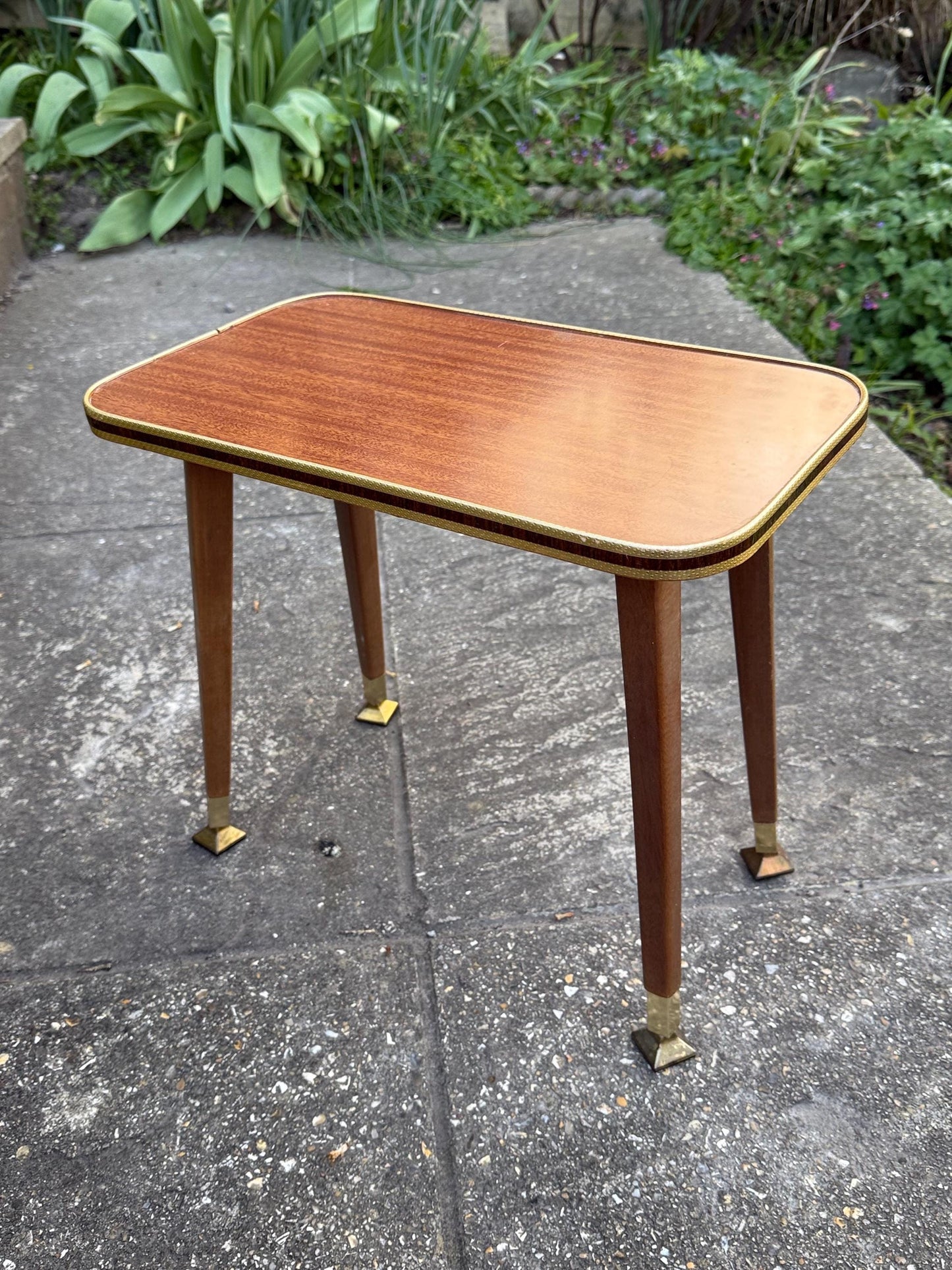 Mid-century modern small table with laminated woodgrain top, tapered legs and metal swivel capped feet