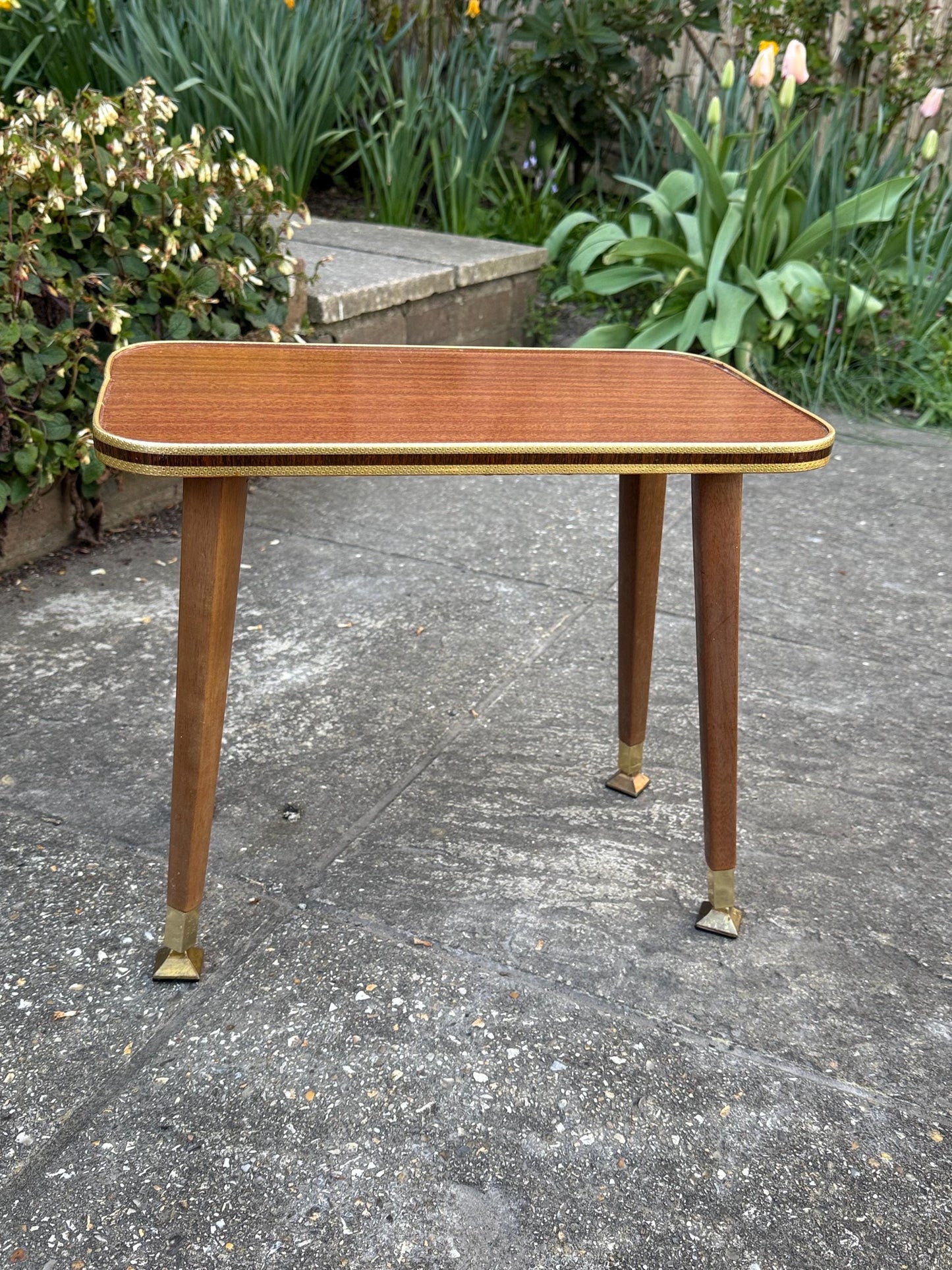 Mid-century modern small table with laminated woodgrain top, tapered legs and metal swivel capped feet