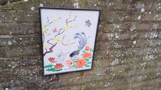 colourful needlework of a peacock andflowers in a black vintage frame