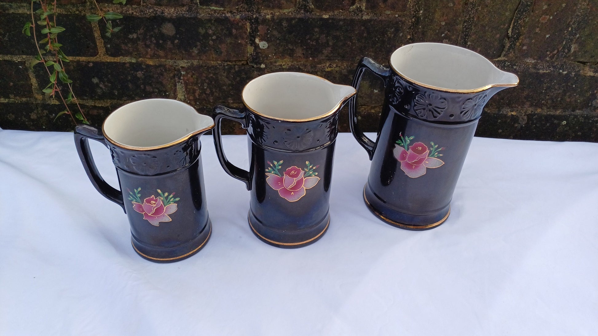 Rare Set of Vintage Victorian Graduated Jugs Black with Pink Flowers Gold Decoration.
