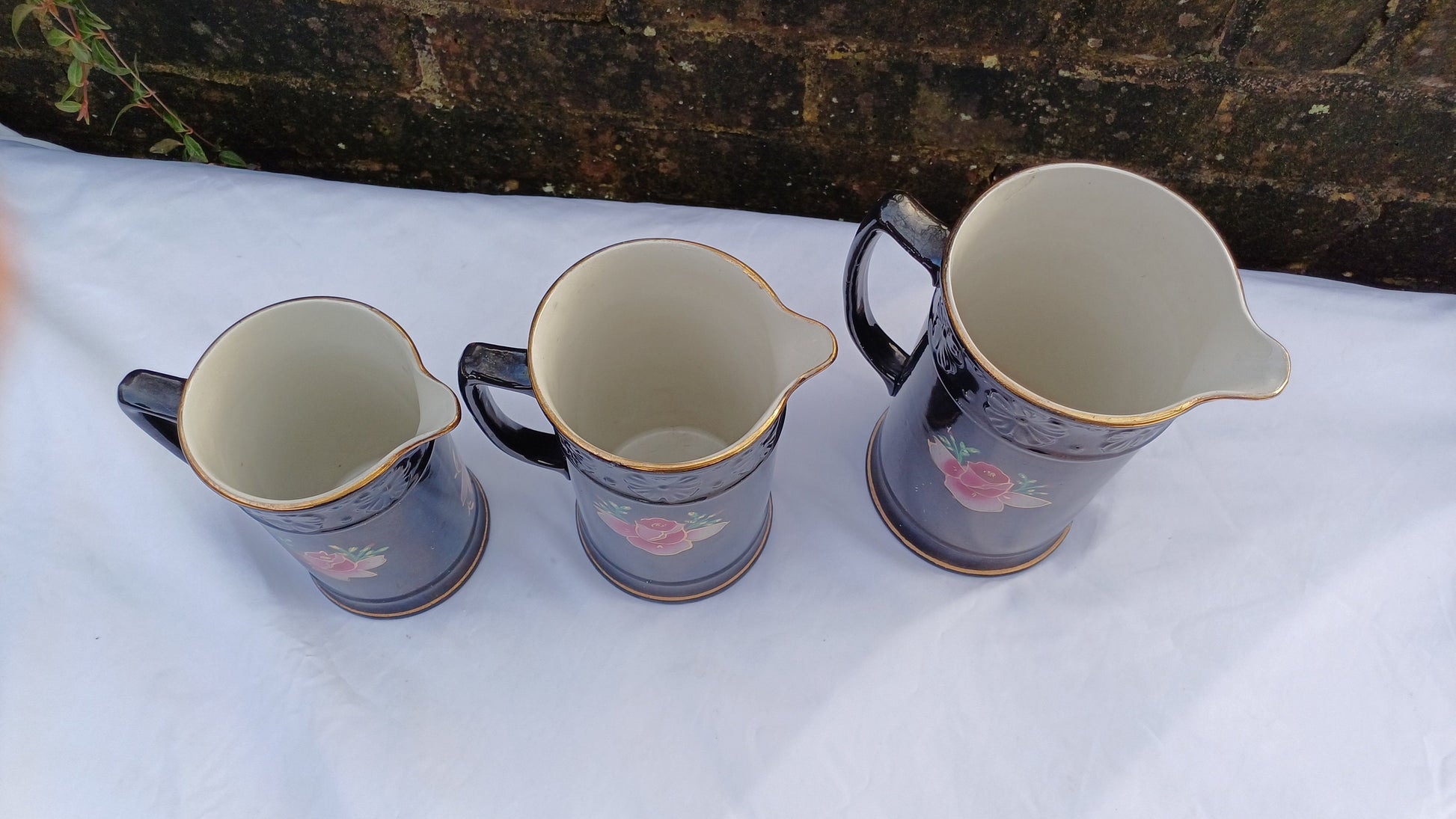 Rare Set of Vintage Victorian Graduated Jugs Black with Pink Flowers Gold Decoration.