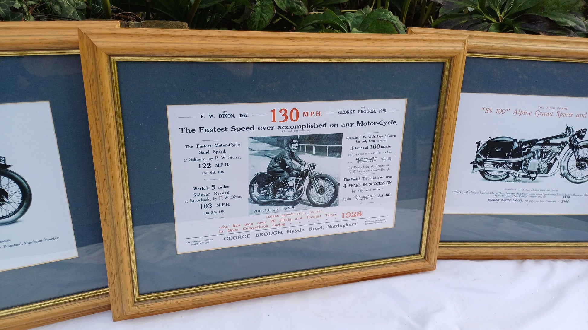 Three Vintage Motorcycle Advertising Prints 'SS100' Alpine Grand Sports and 'Pendine' George Brough with Wooden Picture Frames and Mounts.