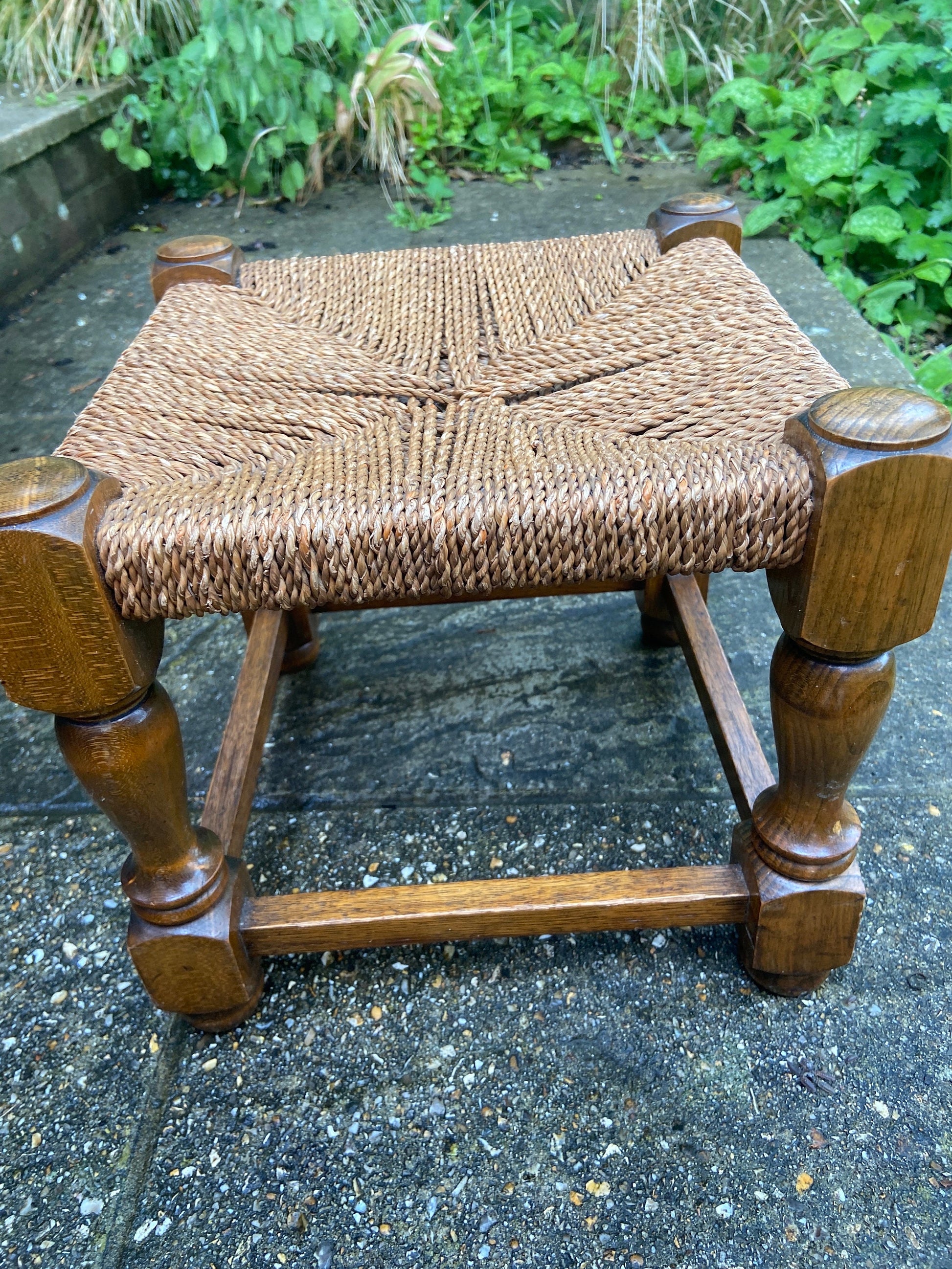 Early twentieth century vintage foot stool, wooden frame with string woven seat, authentic old stool, child stool