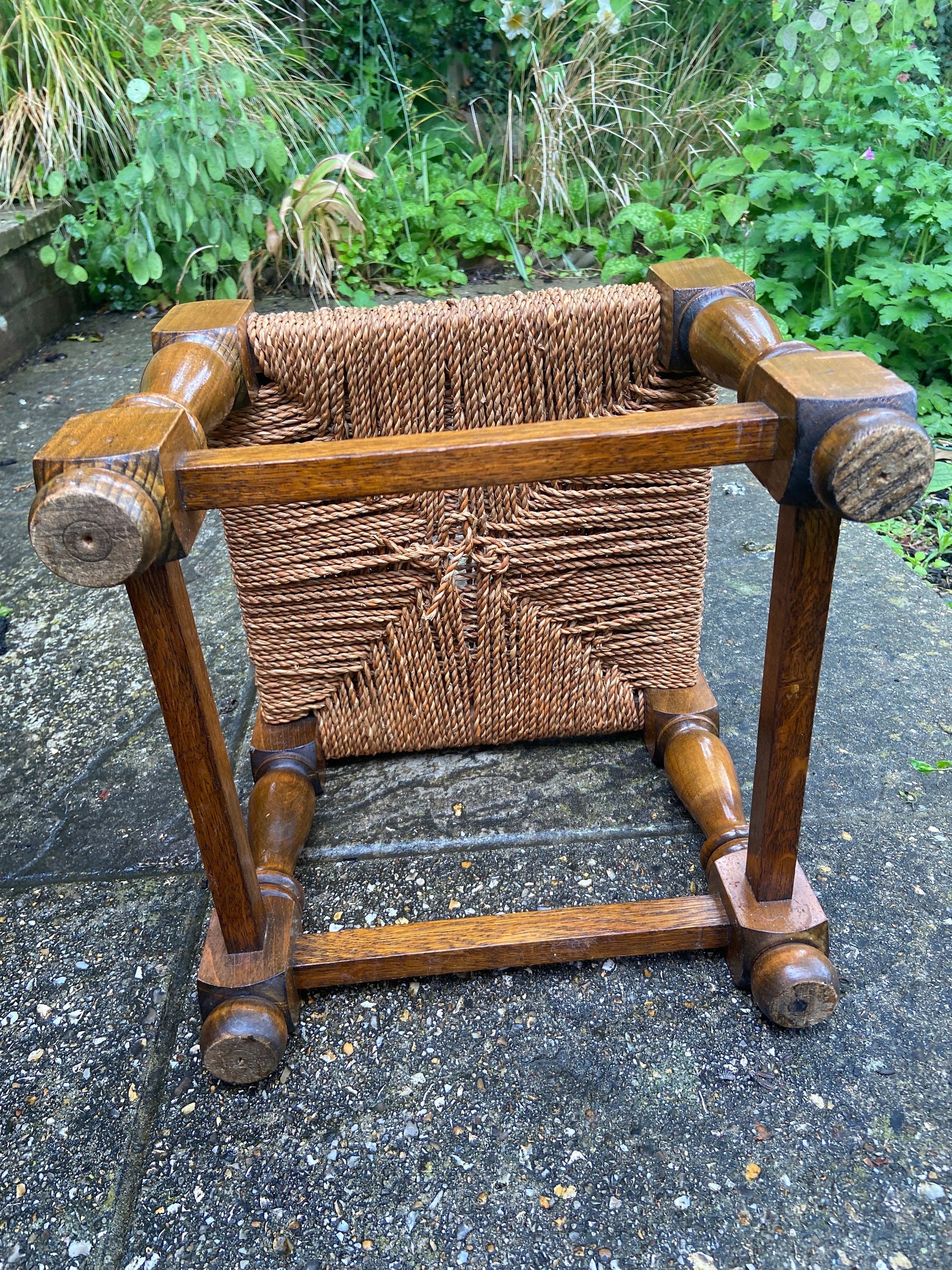 Early twentieth century vintage foot stool, wooden frame with string woven seat, authentic old stool, child stool