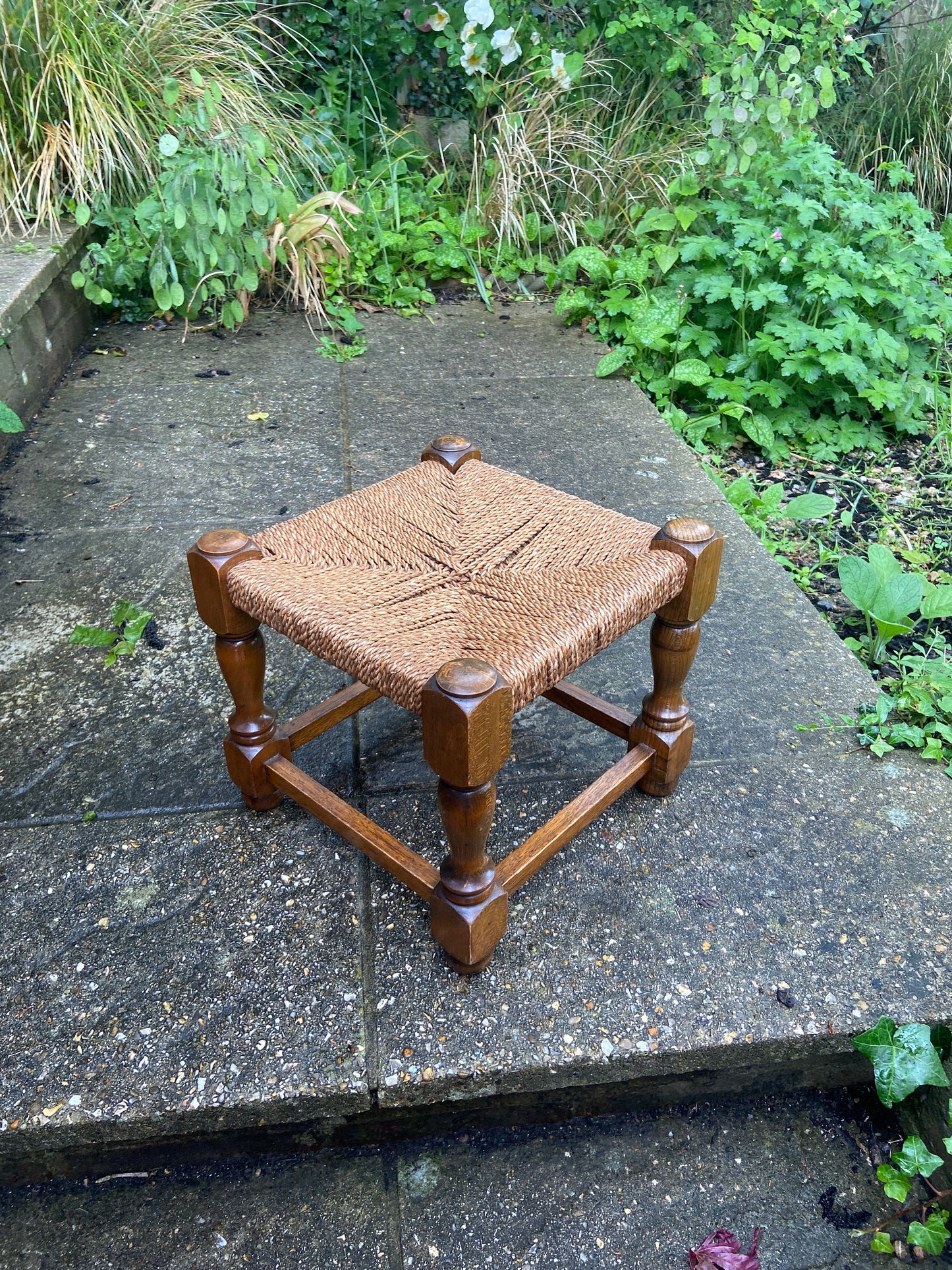 Early twentieth century vintage foot stool, wooden frame with string woven seat, authentic old stool, child stool