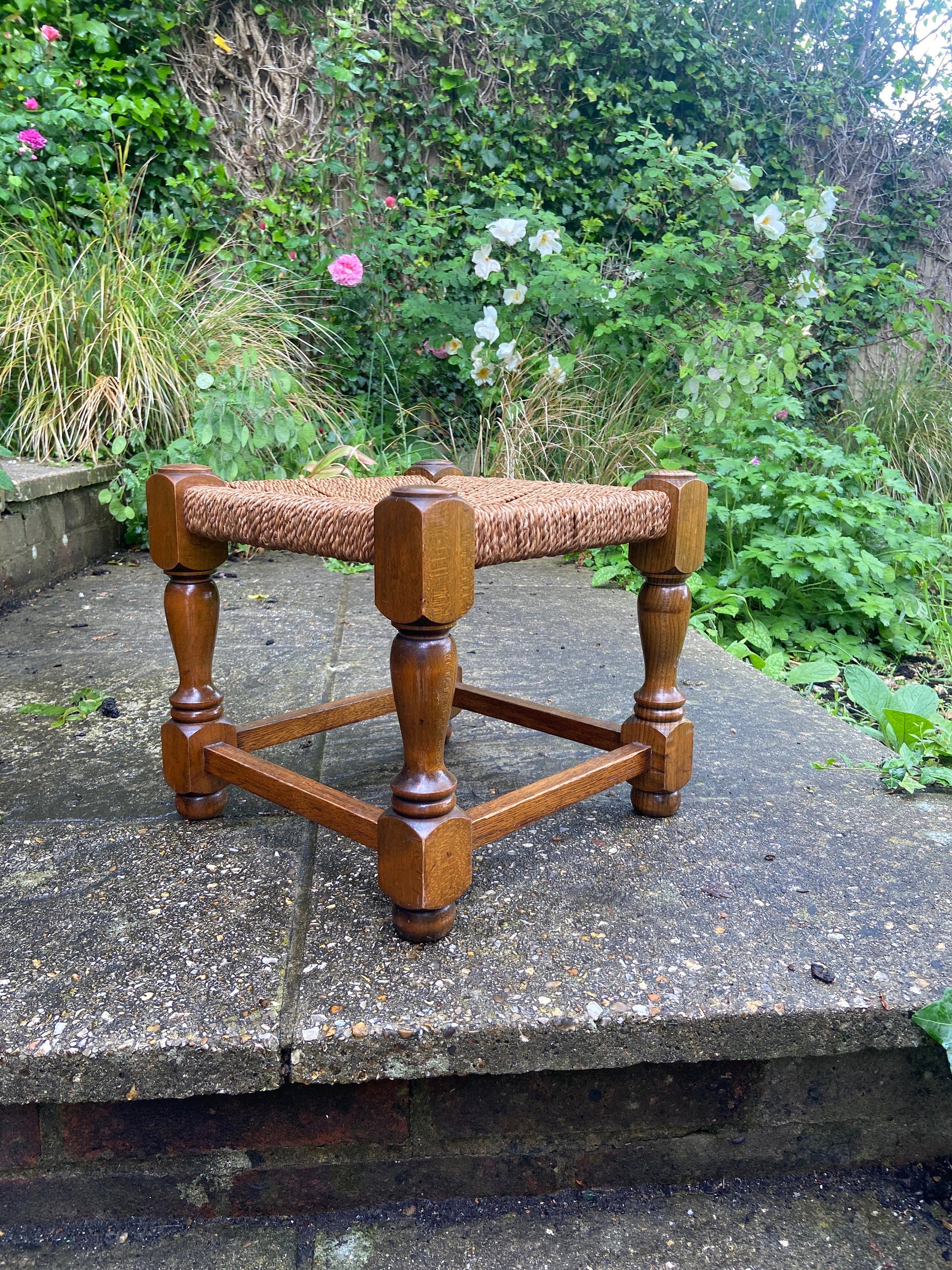 Early twentieth century vintage foot stool, wooden frame with string woven seat, authentic old stool, child stool