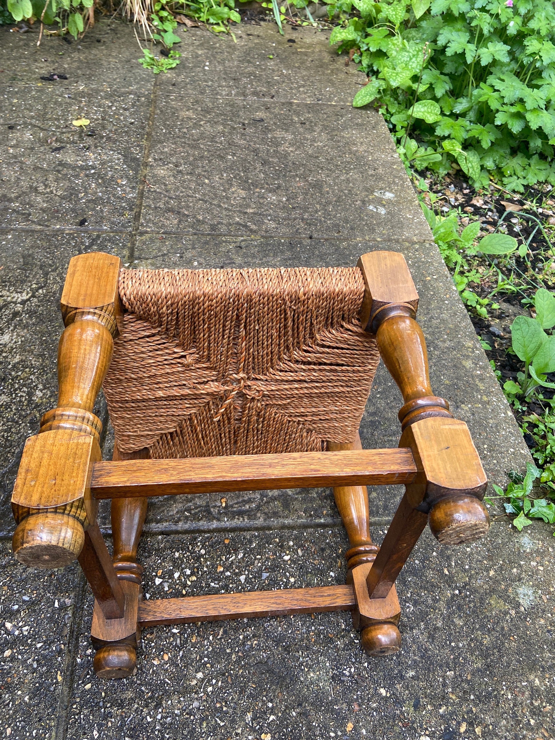 Early twentieth century vintage foot stool, wooden frame with string woven seat, authentic old stool, child stool