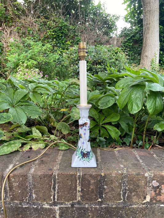 tall candlestick holder style ceramic lamp. working. white ceramic with hand painted butterflies on it. Pretty tall elegant vintage lamp.