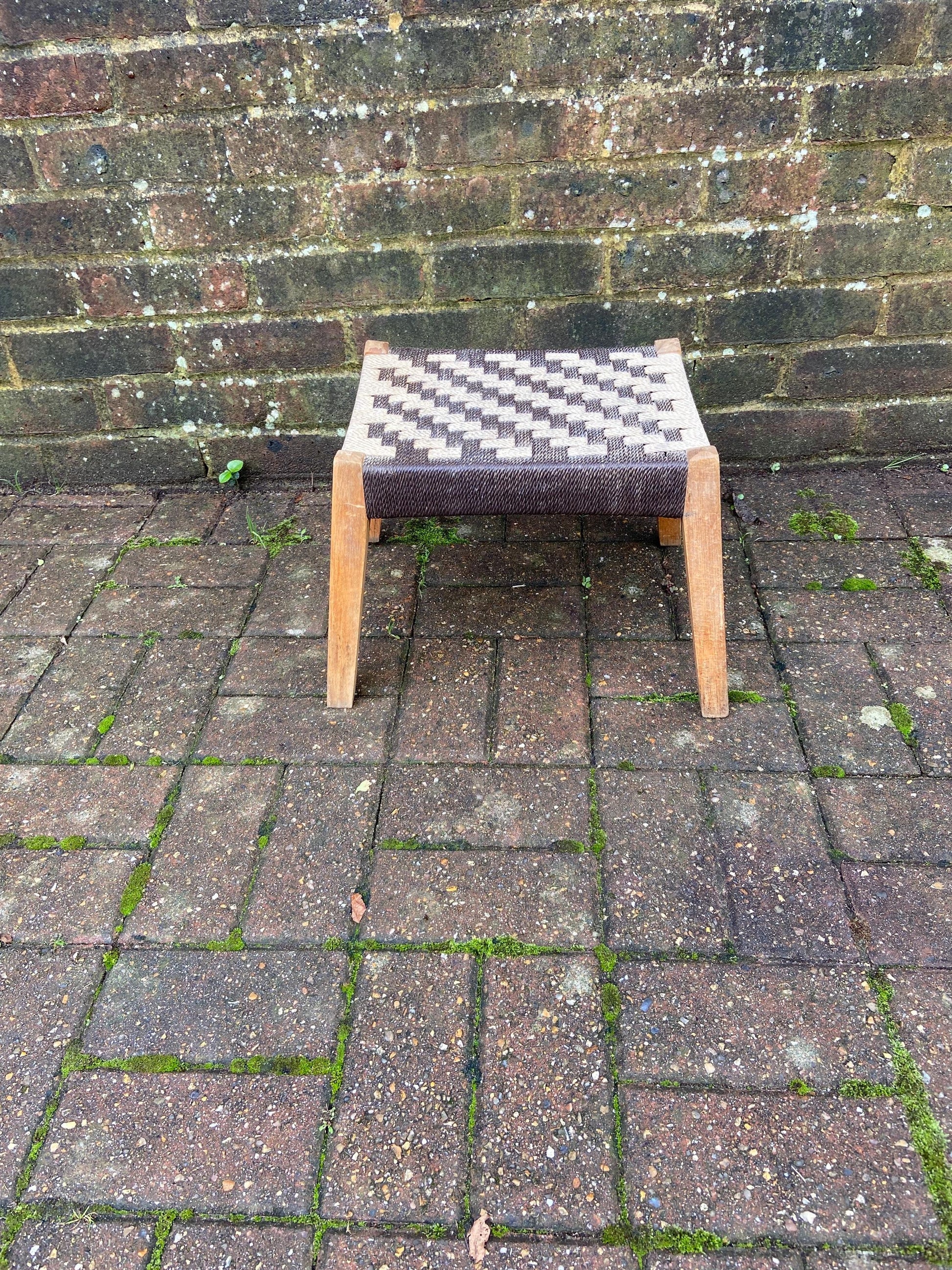strong retro wooden stool with a strung seat. solid. slightly a frame legs. brown beige top.