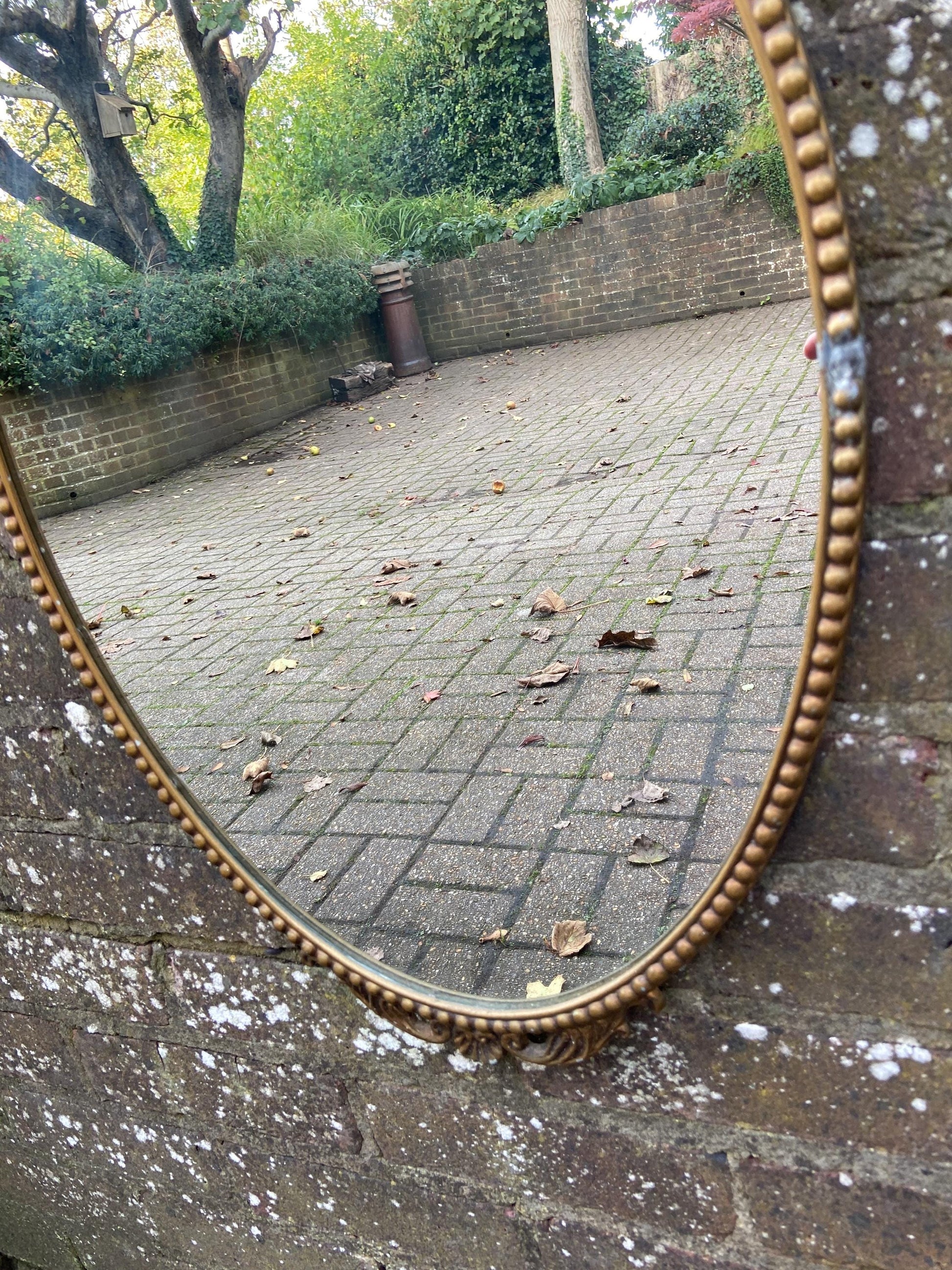Delightful ornate vintage gilt metal framed oval mirror