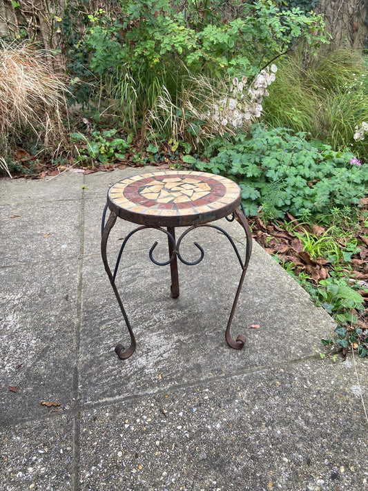 larger wrought iron table with a mosaic top. perfect as a side table, outdoortable or plant stand. rusted finish. solid and heavy