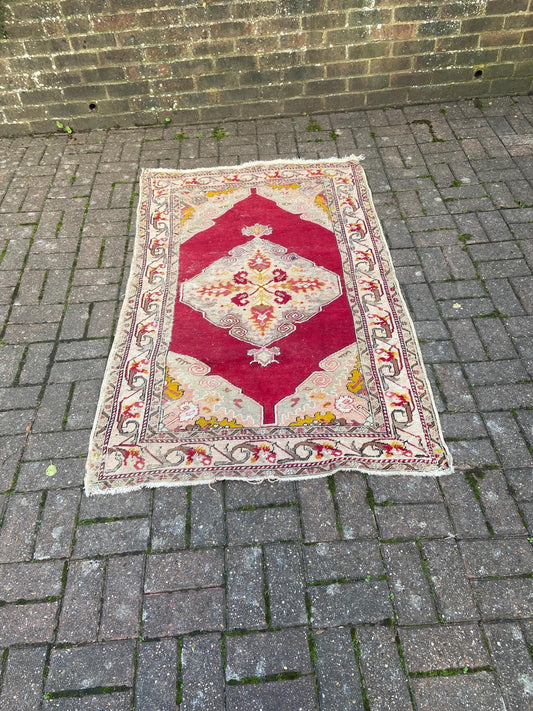 vintage charming aged woollen rug. red and pink and beige and gold