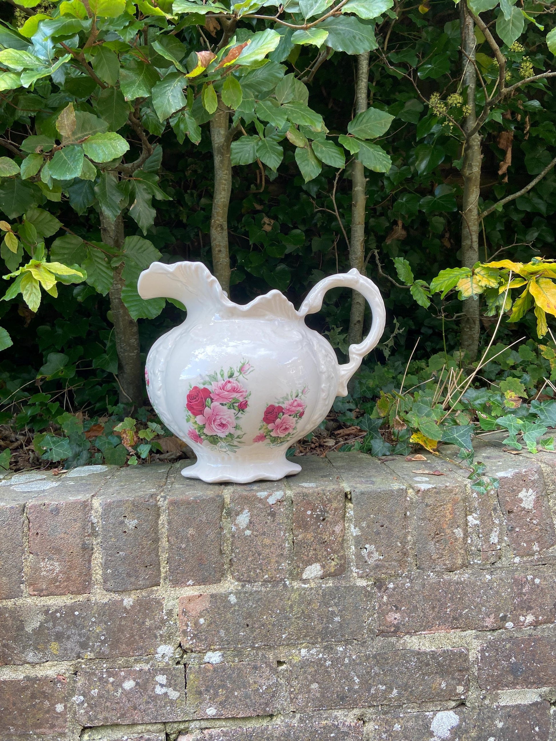 lovely large ceramic china jug made by staffordshire pottery. creamy white with pink and red roses on the front, back and on the inside. invgc although crazing. water tight socan be used to hold liquids or a vase