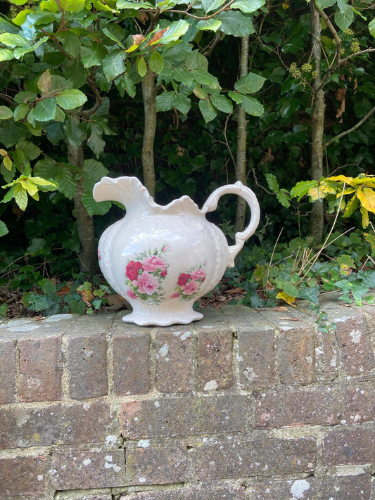 lovely large ceramic china jug made by staffordshire pottery. creamy white with pink and red roses on the front, back and on the inside. invgc although crazing. water tight socan be used to hold liquids or a vase