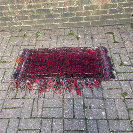 antique woollen rug, frayed and characterful. has a matching backing and also means to use as a wall hanging