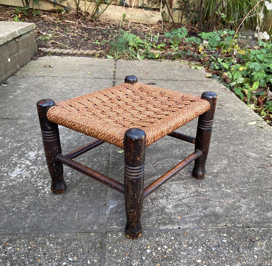 vintage string woven stool on dark wooden frame.  Brown string.  likely Early 1900s.  Sturdy. Good condition