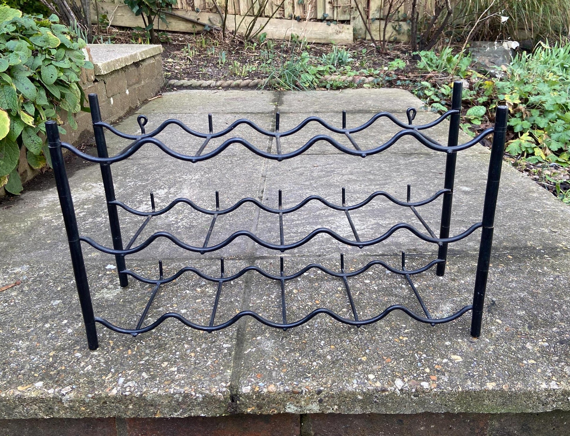 wall or surface mounted plastic and metal black wine rack from the 1970s. retro wine rack. 10 or 15 bottles