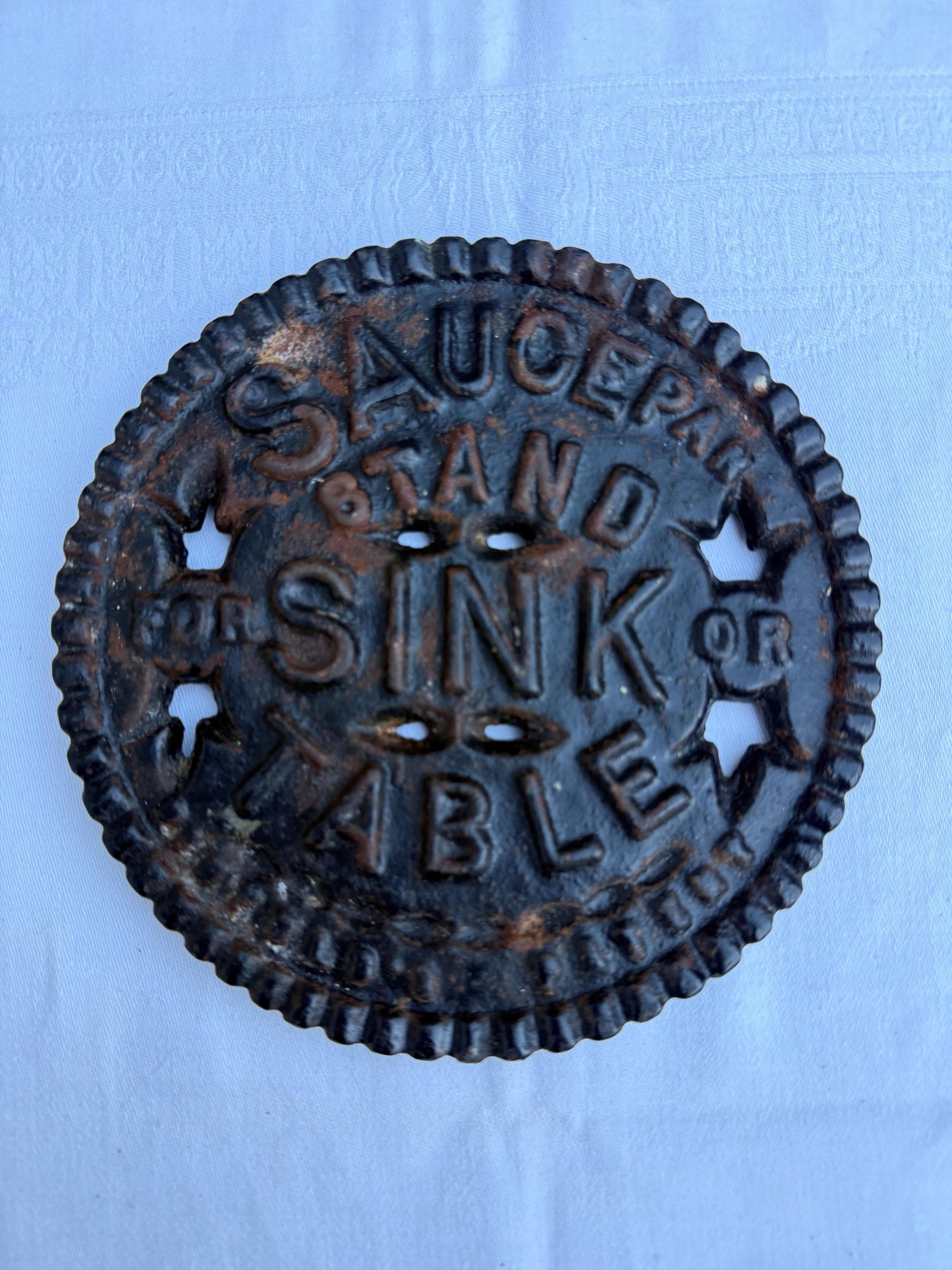 Fantastic heavy iron tivert or pot stand with wording "Saucepan stand for sink or table" - great for kitchens and tables 17cm wide