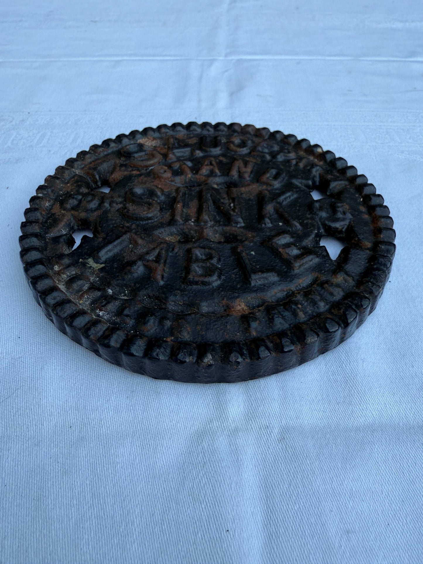 Fantastic heavy iron tivert or pot stand with wording "Saucepan stand for sink or table" - great for kitchens and tables 17cm wide