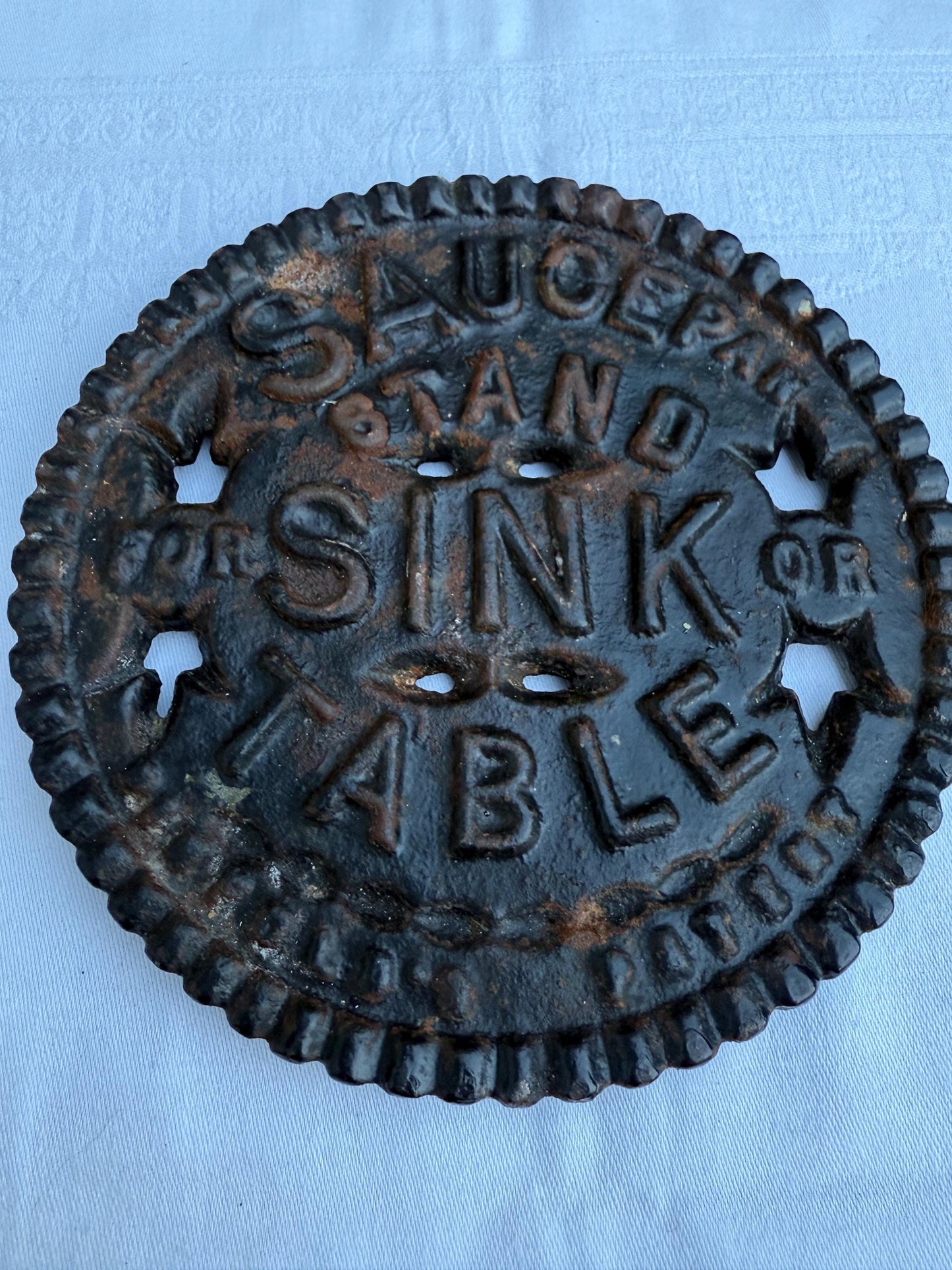 Fantastic heavy iron tivert or pot stand with wording "Saucepan stand for sink or table" - great for kitchens and tables 17cm wide