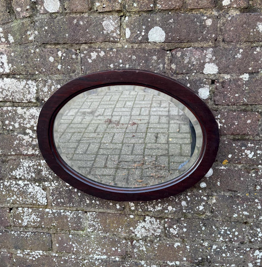 lovely vintage wooden mirror with bevelled glass, in a oval wooden frame.  likely antique.