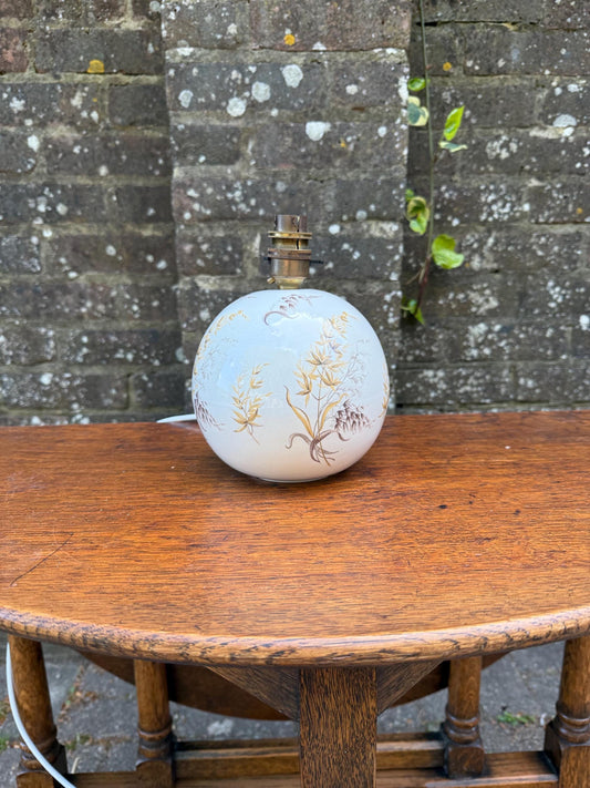 retro floral motif botanical esign round globe shaped table lamp. white ceramic lamp with hand decorated brown leaf detail. small bedside lamp