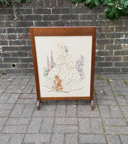 early 1900s fire screen with lovely delicate needlework of a crinolin lady. in an oak fire screen frame. dark wood with light embroidery