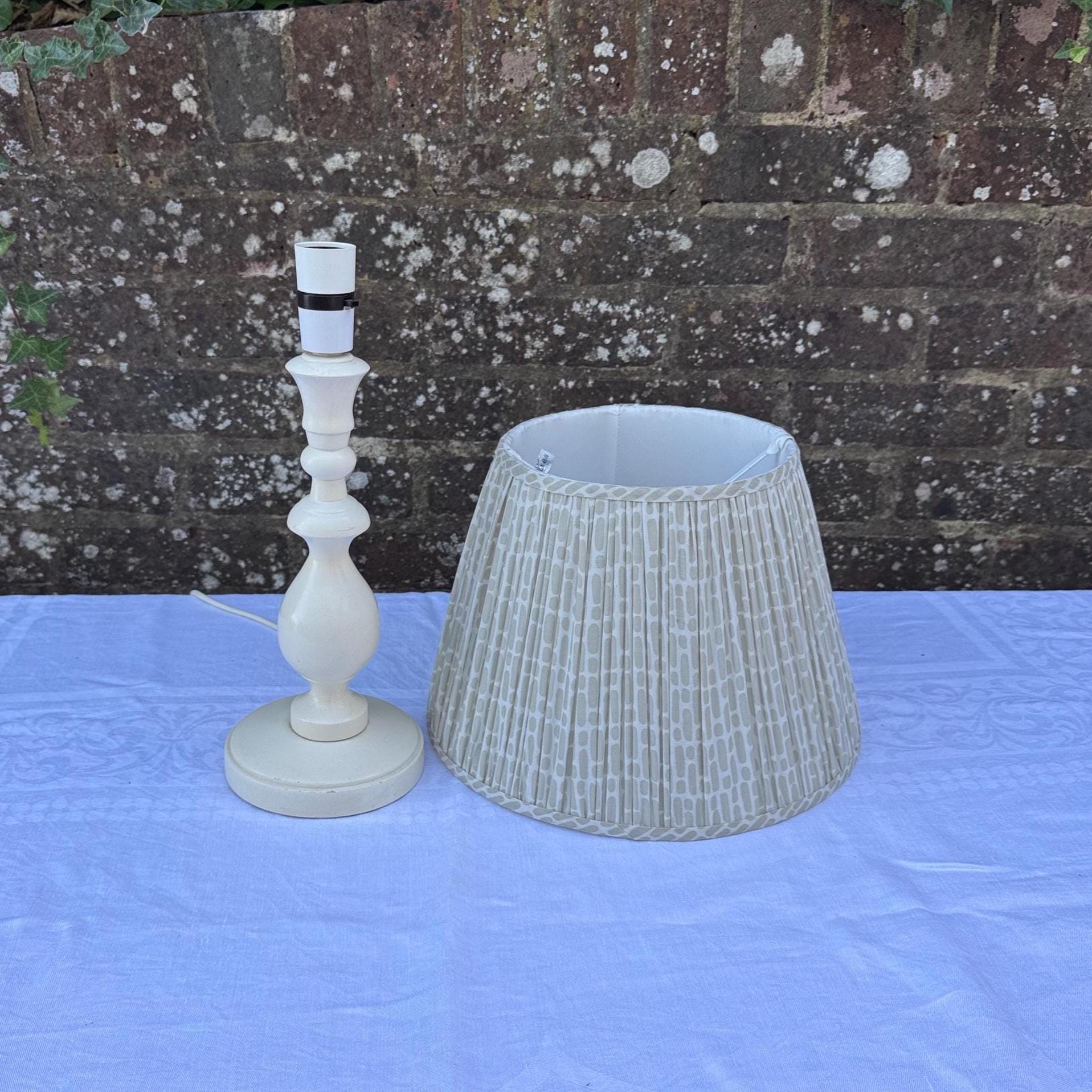 painted wooden lamp with lovely turned column and round base. comes with neutral coloured cotton lined shade with geometric pattern. clean and tidy.