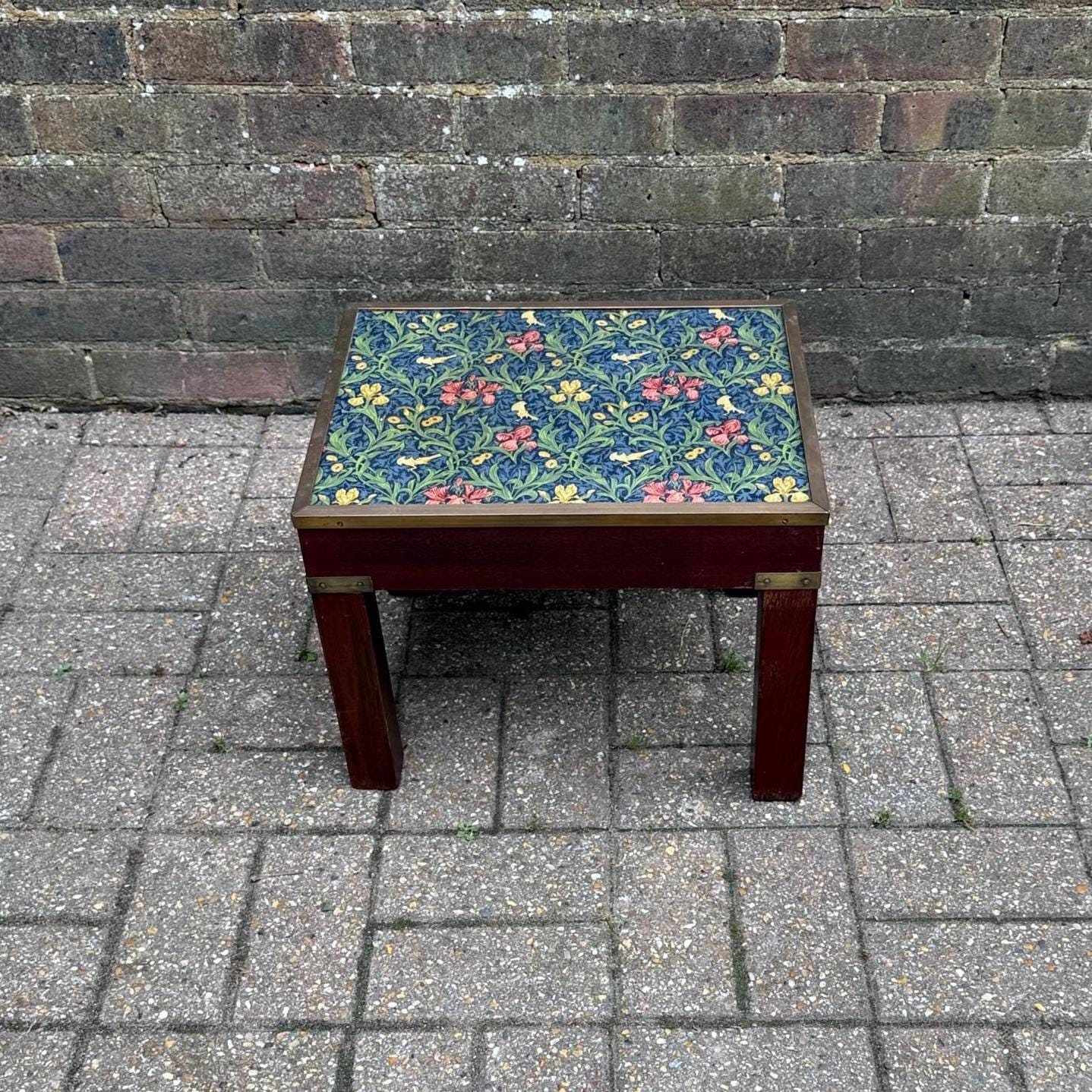vintage wooden table in dark hardwood and brass. Glass table top with william morris material underside. plant stand or side table
